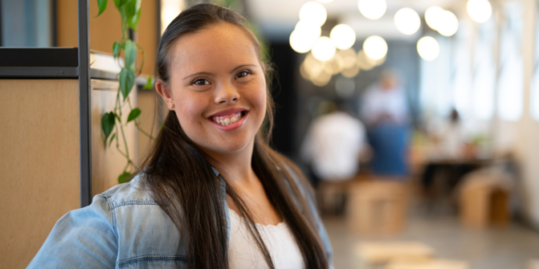 Woman with a lanyard smiling at work.