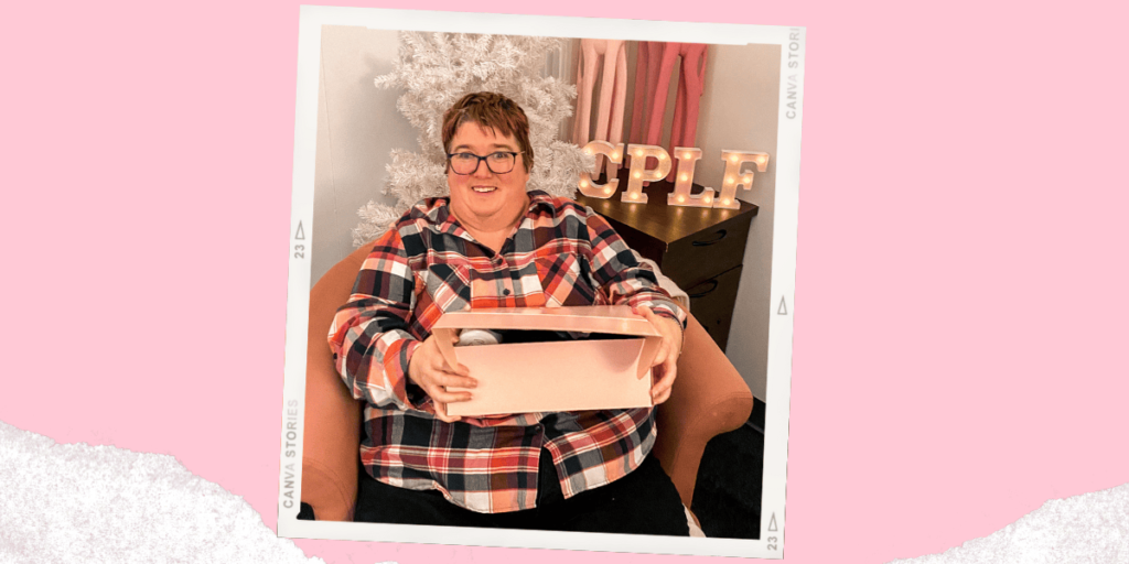 Jessica Sproule holding a pink box and smiling.